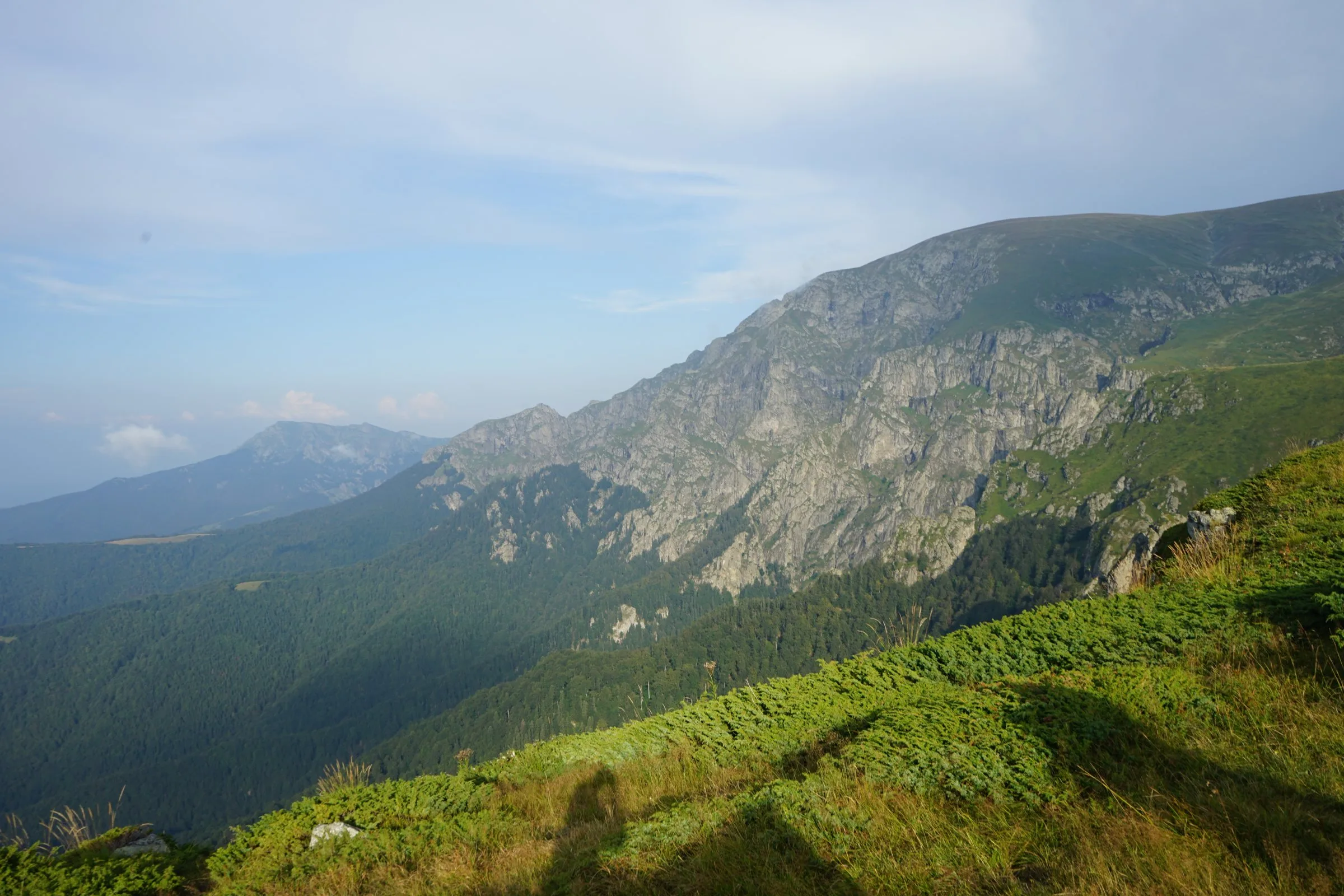 Green slopes and rocky ridges of the Central Balkan mountains under a blue sky