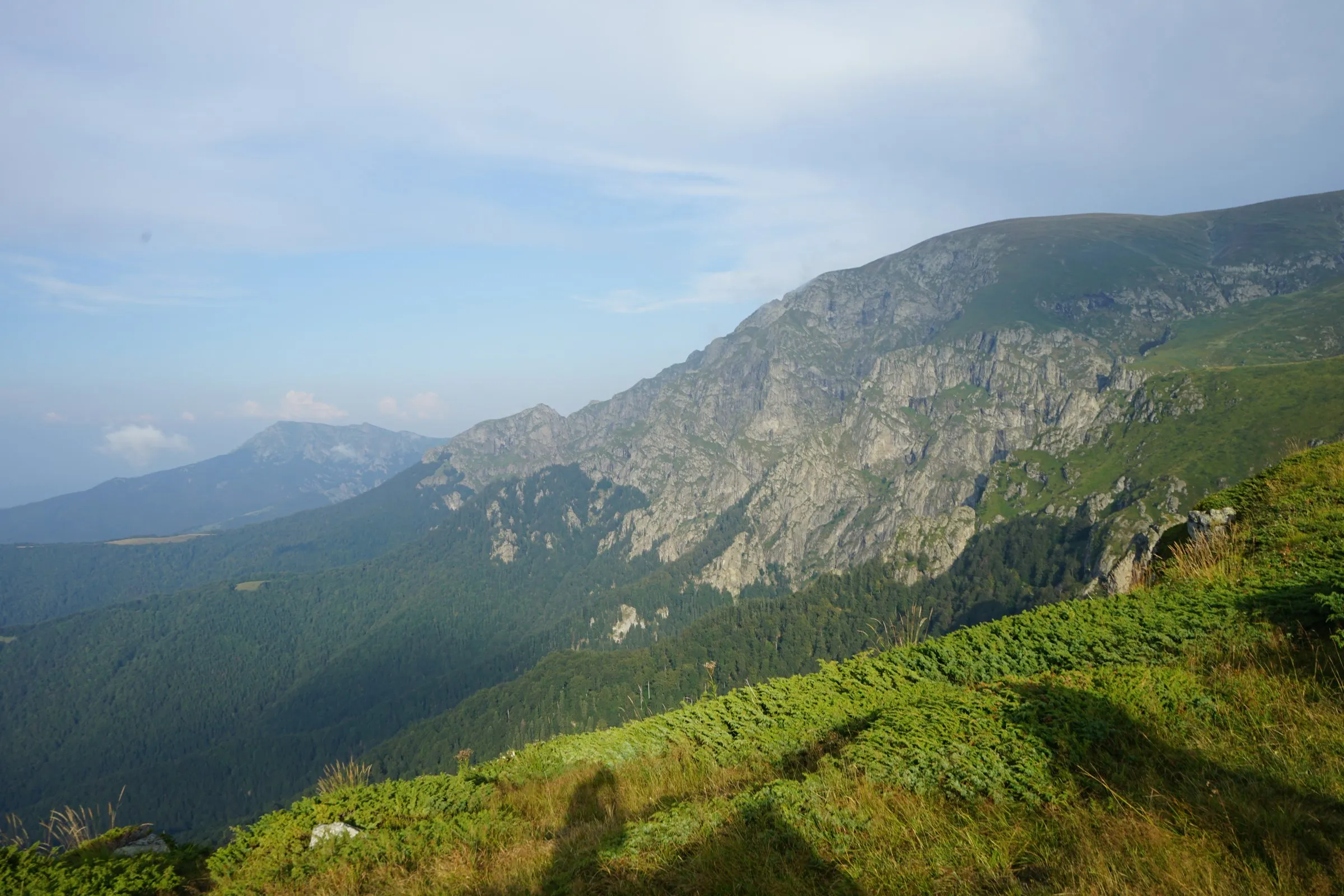 Green slopes and rocky ridges of the Central Balkan mountains under a blue sky
